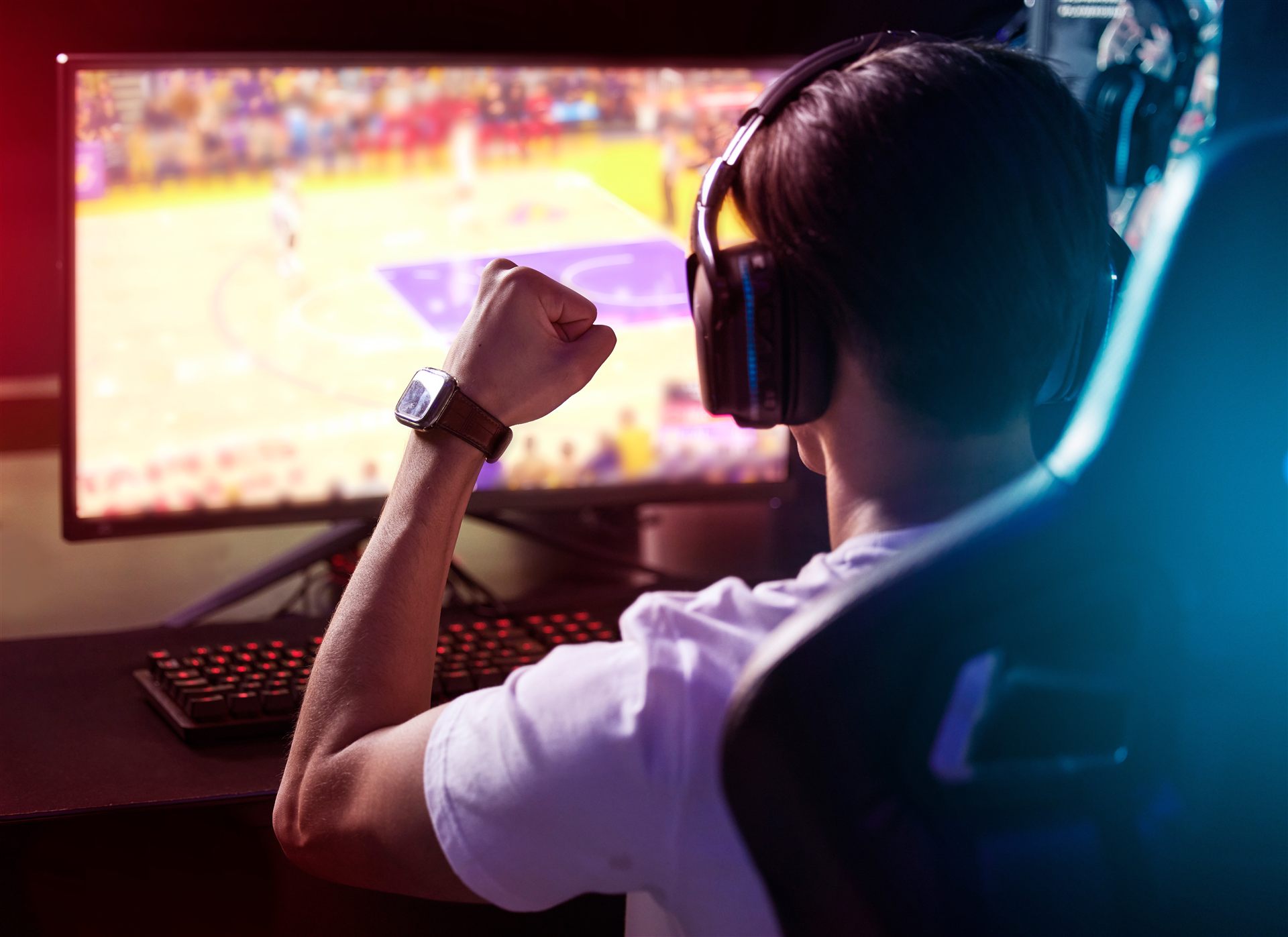 Excited gamer celebrating a win at their setup